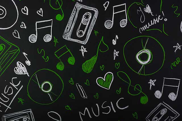 Drawn musical notes with cassette tape; compact disc on blackboard Free Photo